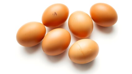 Brown eggs on a white surface, showcasing natural texture and subtle shadows in a minimalist composition.