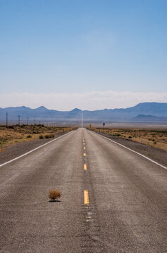 Extraterrestrial highway, US route 375, Nevada, USA, with a tumbleweed blowing by, long straight road into the desert