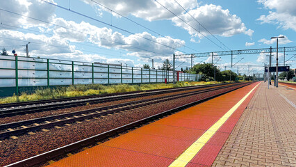 Village railway station platform with a shelter and seats on a sunny summer day with the rail track in perspective disappearing to a vanishing point on the horizon, Nottinghamshire, England, UK