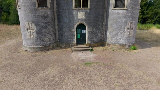 Aerial drone shot of Blaise Castle, Henbury, Bristol. Starting at ground level facing the castle front, the drone and flies up and forward, tilting down into a top-down view directly over the turrets.