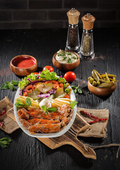 Traditional Turkish Doner Kebab Plate with Fresh Vegetables, French Fries, and Sauces on Rustic Background