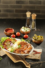 Traditional Turkish Doner Kebab Plate with Fresh Vegetables, French Fries, and Sauces on Rustic Background