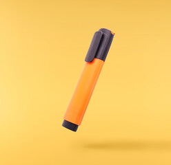 Back to school conception. Flying in the air school equipment. A textmarker   levitating in the air isolated on yellow background