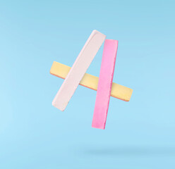 Back to school conception. Flying in the air school equipment. A chalk levitating in the air isolated on blue background