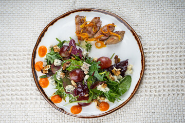 fresh vegetable salad with veal and greens in a  plate