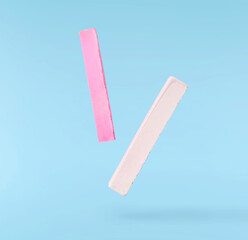 Back to school conception. Flying in the air school equipment. A chalk levitating in the air isolated on blue background