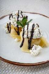 pancakes with cheese filling, meat and chocolate sauce on a plate