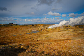 Vast geothermal plains in Iceland breathe with rising steam, painting a surreal landscape where earth, sky, and hidden fire converge.
