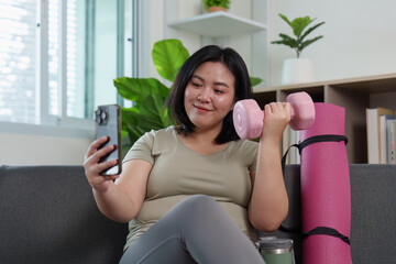 Joyful Fitness: Woman Smiling While Holding Dumbbell and Smartphone