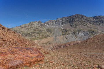 Panorama on Punta del Lago Bianco summit and Mulenza glacial circus, with red rocks foreground, Vallelunga, Alto Adige - Sudtirol, Italy. Moraines of 1850 age are visible