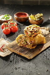 "Traditional Turkish Doner Kebab Plate with Fresh Vegetables, French Fries, and Sauces on Rustic Background"