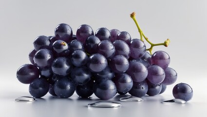 Fototapeta premium Clusters of purple grapes with water droplets on a white background.