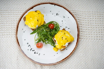 breakfast with poached egg in a plate with microgreens on a white background