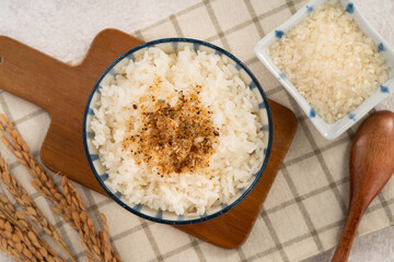 A bowl of white rice topped with sprinkle rice seasonings.