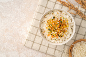 A bowl of white rice topped with sprinkle rice seasonings.
