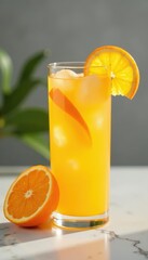 Fototapeta premium Iced orange juice with orange slices in tall glass on marble , still life, food photography