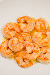 Cooked shrimps in oil with shiny texture. Close up of boiled seafood prawns, ready to eat, isolated on background for menu, restaurant, food styling or healthy gourmet concept.