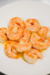 Cooked shrimps in oil with shiny texture. Close up of boiled seafood prawns, ready to eat, isolated on background for menu, restaurant, food styling or healthy gourmet concept.