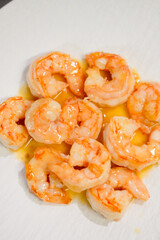 Cooked shrimps in oil with shiny texture. Close up of boiled seafood prawns, ready to eat, isolated on background for menu, restaurant, food styling or healthy gourmet concept.