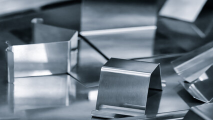 metal pieces are being cut by machine. pieces all same size and shape, and they are arranged in a...