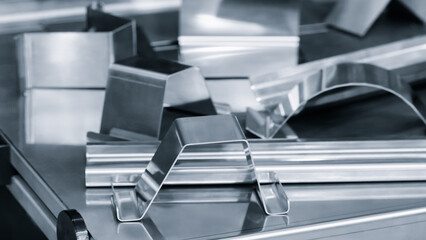 metal pieces are being cut by machine. pieces all same size and shape, and they are arranged in a...