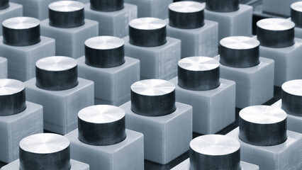 Row of metal cylinders are lined up in a row. The cylinders are all the same size and shape