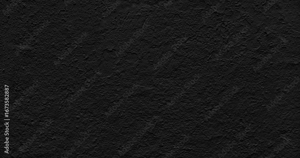Poster wall in a rich black with a rough, uneven texture as background. it is made of concrete or another m