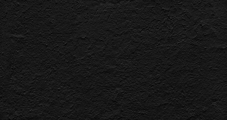 wall in a rich black with a rough, uneven texture as background. It is made of concrete or another material textured to create a unique, visually interesting surface.