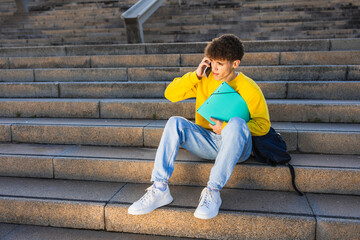 College student talking on smartphone while sitting on stairs outdoors