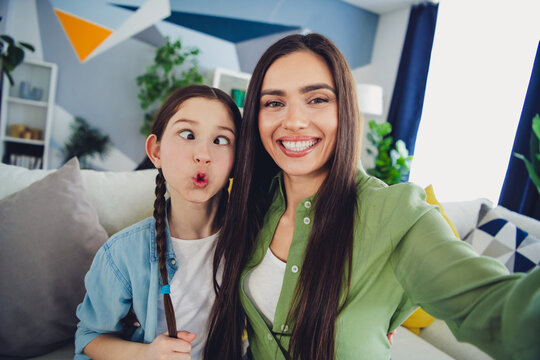 Happy mother and daughter enjoying a playful moment together indoors, bonding and creating lasting family memories