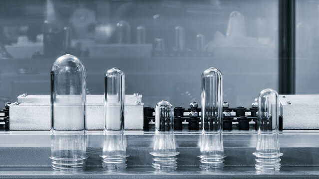 PETG plastic preforms for bottle making on the conveyor belt before the hot blow molding machine