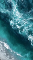 Aerial view of turquoise ocean water with white foam and waves crashing in