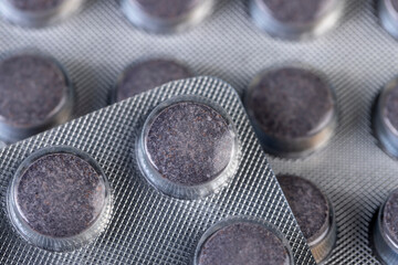 cylindrical purple tablets made from natural ingredients packed in a blister , whole purple tablets packed in a metal-plastic blister with the addition of blueberry extract and other ingredients