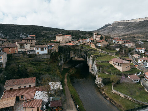 Aerial view of the village perched atop a natural bridge with quaint buildings in the valley below, Puentedey, Castile and Le&Atilde;&sup3;n, Spain.