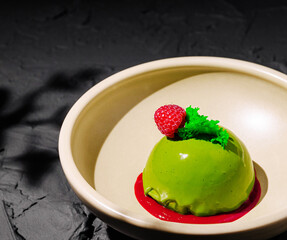 Delightful green dessert served with raspberry and mint garnish in elegant bowl