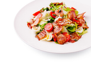 Fresh salad with crispy bacon and mixed vegetables on a white plate
