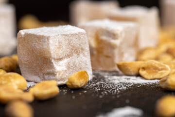 Turkish delight in with nuts , scattered oriental sweets Turkish delight with peanuts on a slate board