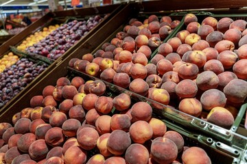 Fresh peaches stacked in a supermarket fruit display