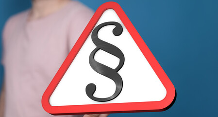 Stock photo of a person holding a red triangle warning sign with a paragraph symbol.  Perfect for...