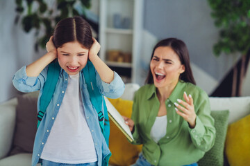 Mother and daughter expressing emotions during a lively moment at home in a bond of family...