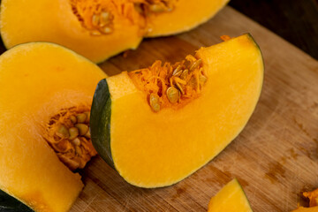 bright orange ripe pumpkin for cooking, cut into pieces sweet pumpkin in the kitchen, close up