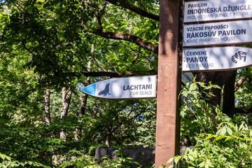 A pole with signs directing visitors to animals in Prague Zoo in Czech Republic