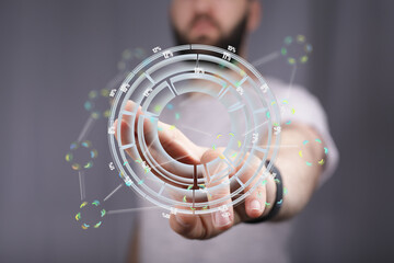 Stock photo of a man interacting with a holographic circular chart displaying data percentages.
