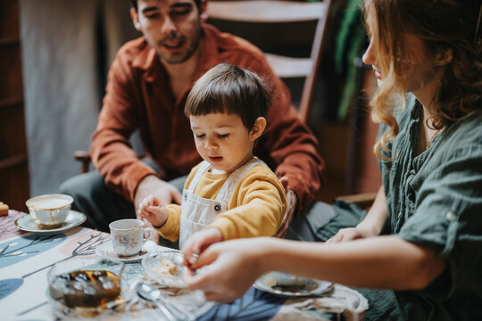 Family bonding moment as parents and their child enjoy a cozy meal at home. A charming instance of familial love and togetherness enhanced with a warm and inviting ambiance.
