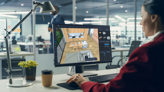 Female Interior Designer Using Advanced 3D Modeling Software on a Desktop Computer to Create a Modern Living Room and Bedroom Space Layout. Specialist Creating a Stylish Environment for a Client
