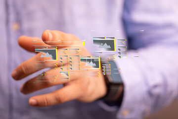 Close-up of a hand interacting with a digital interface showing data and images. Technology concept.