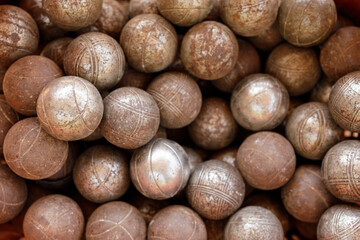 Close-up of many vintage bocce balls, showing wear and texture. Perfect for sports, leisure, and...