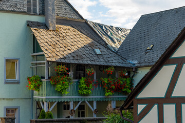 Charming balcony adorned with vibrant flowers in a picturesque village under a bright blue sky