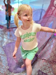 Fillette de 3 ans souriante portant un t-shirt vert "Bonjour". © Mathieu