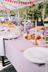 Elegant outdoor dining setup with flowers and food for a festive gathering